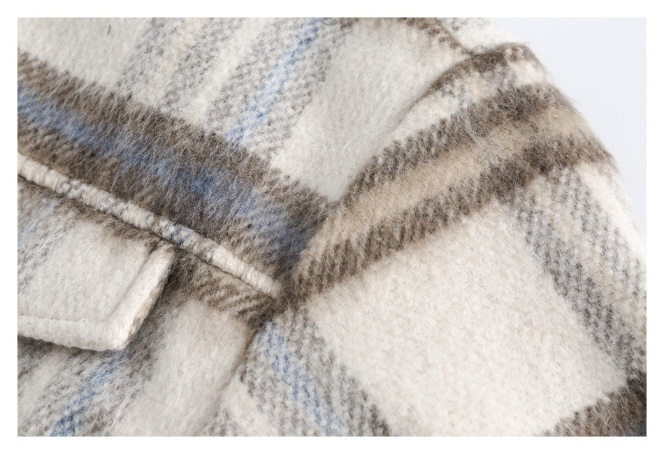 Close-up of the plaid garment's shoulder seam and cream, taupe, and pale blue fabric.