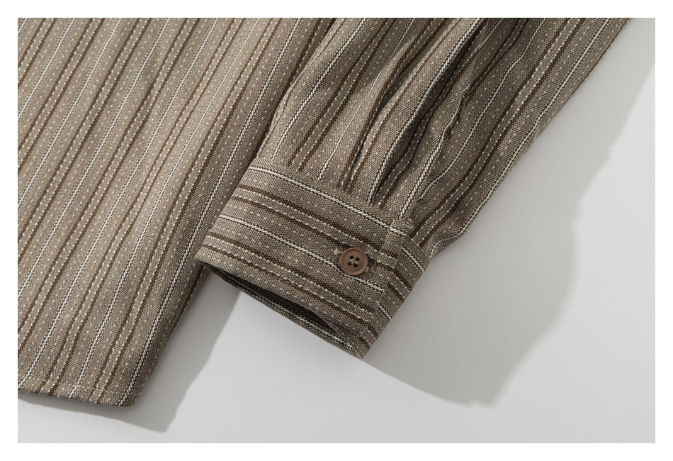 Close-up of a striped brown shirt sleeve and buttoned cuff.