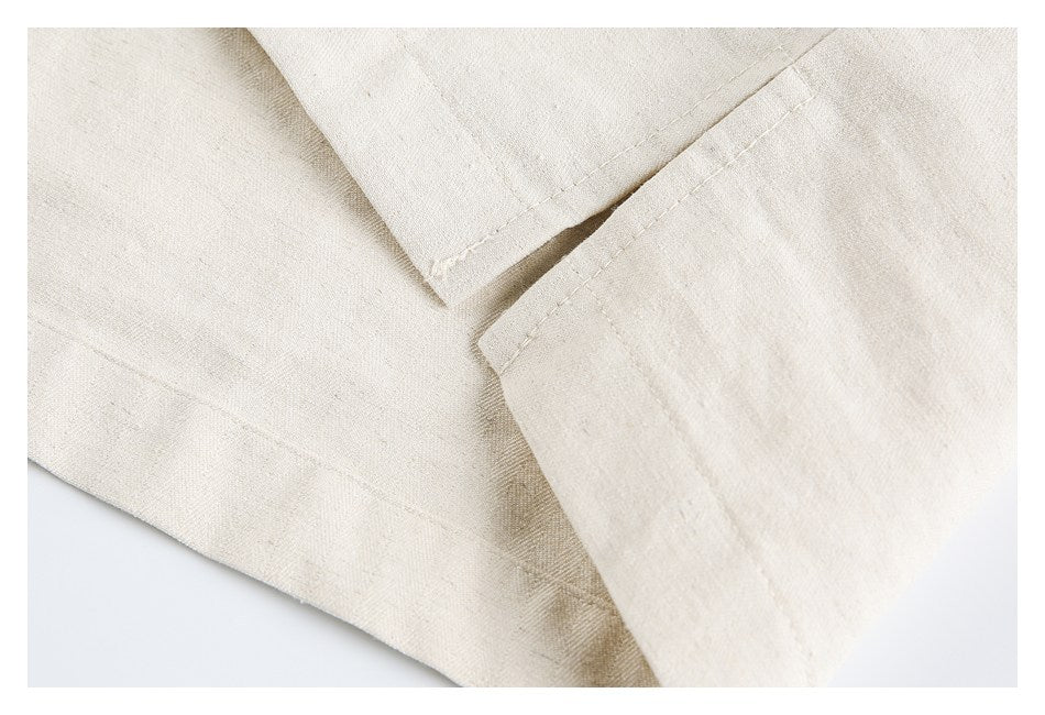 Close-up of overlapping stitched edges on a light beige garment.