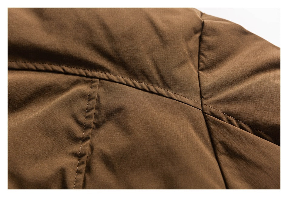 Close-up of brown jacket panel seams and stitching near a sleeve seam.