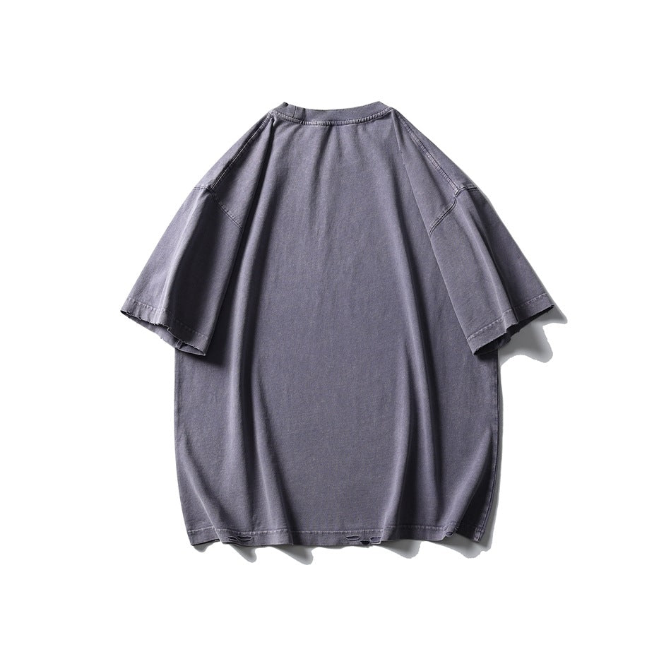 Back view of an oversized faded lavender-gray short-sleeve T-shirt with a crew neck and distressed hem details.