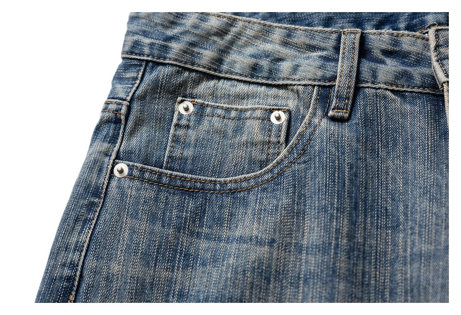 Close-up of the front pocket and small coin pocket on faded blue jeans.