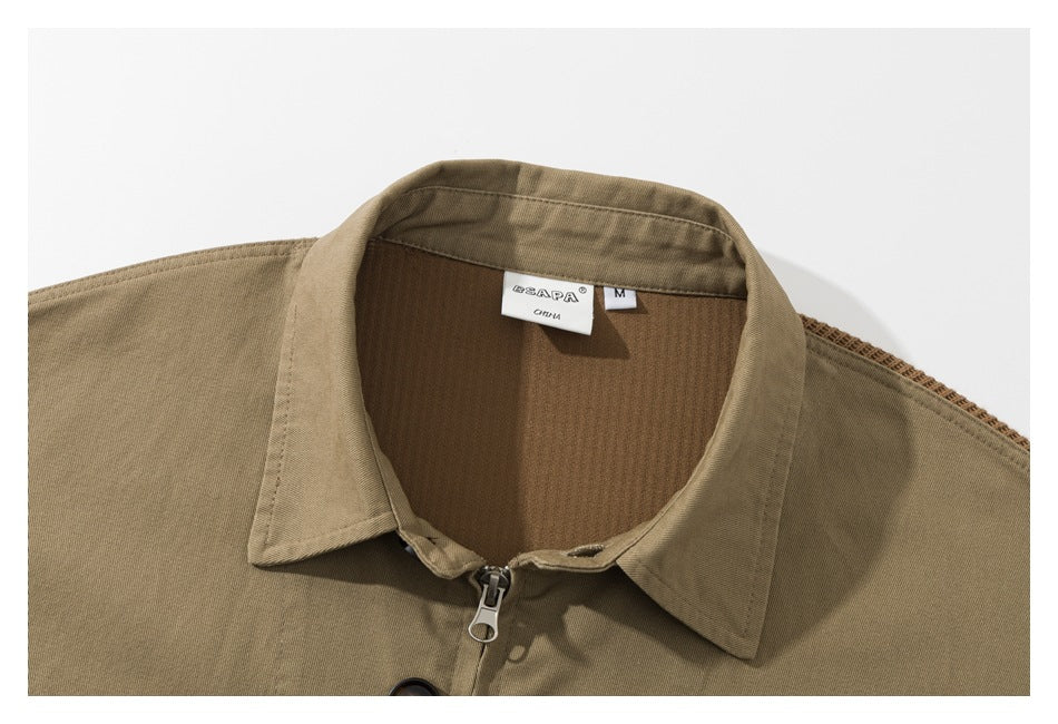 Close-up of a tan shirt-jacket collar with a front zipper and visible neck and size labels.
