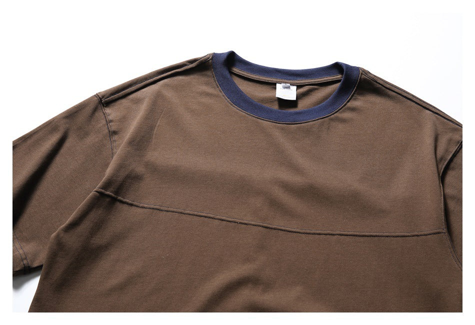Close view of a brown short-sleeve T-shirt front with a navy ribbed crew neck and curved chest seam.