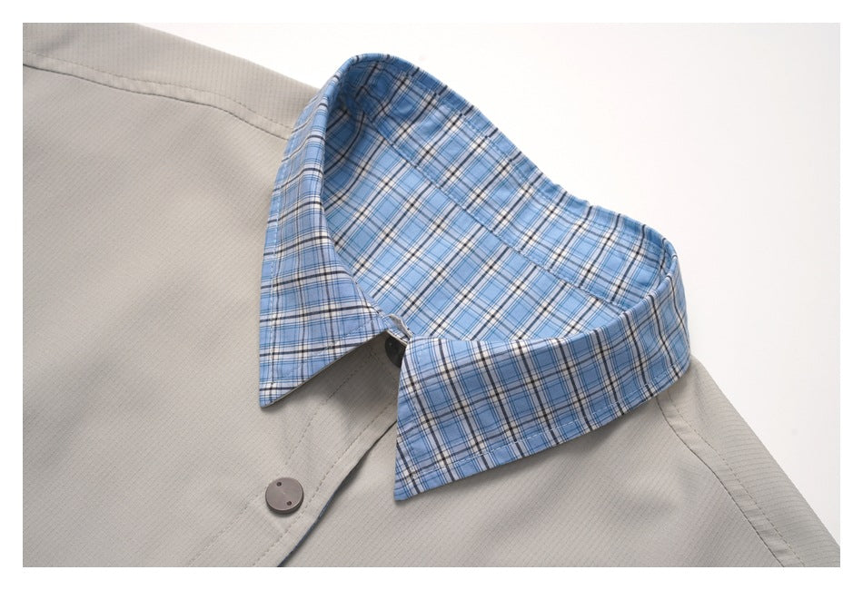 Close-up of a pointed blue plaid collar against the garment's light gray lining.
