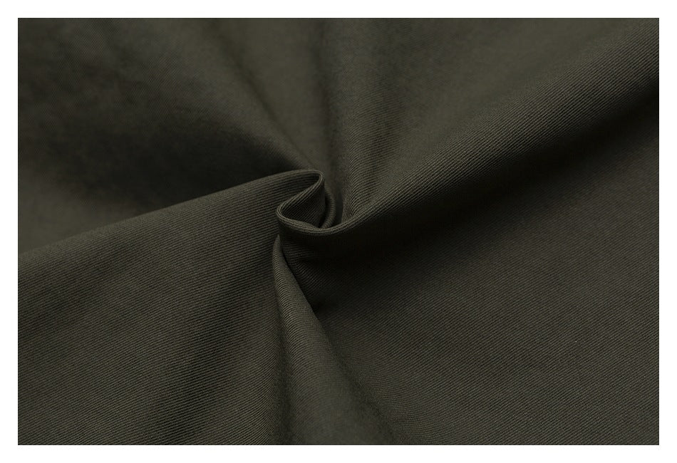 Close-up of dark olive fabric folded to show its fine diagonal texture.