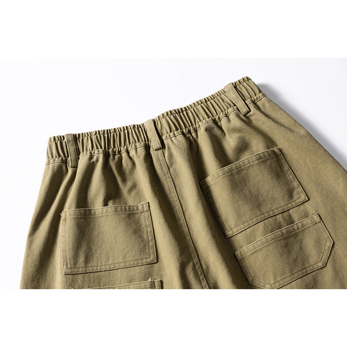 Close-up of the olive-khaki shorts' elastic back waistband and multiple patch pockets.