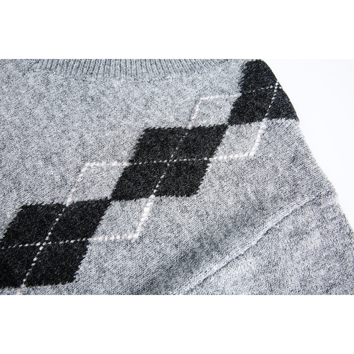 Close-up of a gray sweater's black argyle diamond pattern with fine dotted accents.
