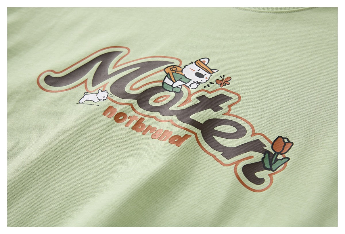 Close-up of a pale green garment with a large playful graphic, cartoon animals, and English lettering.