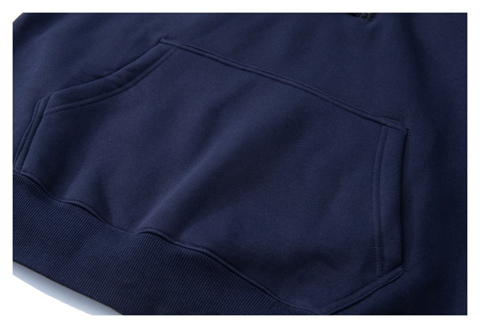 Close-up of the navy pullover's front kangaroo pocket and ribbed hem.