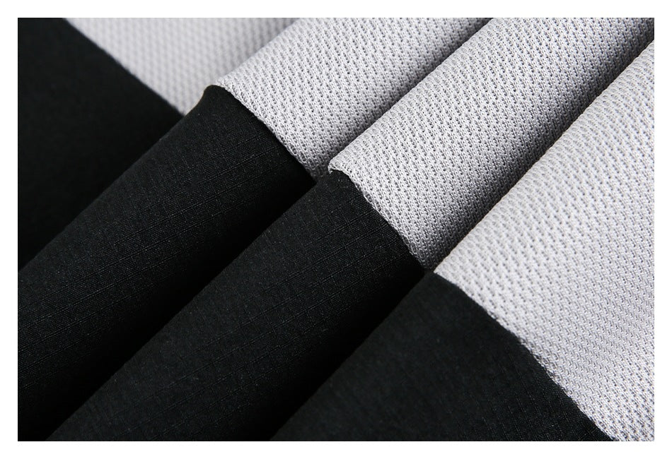 Close-up of folded black and light gray garment fabric showing its contrasting textures.