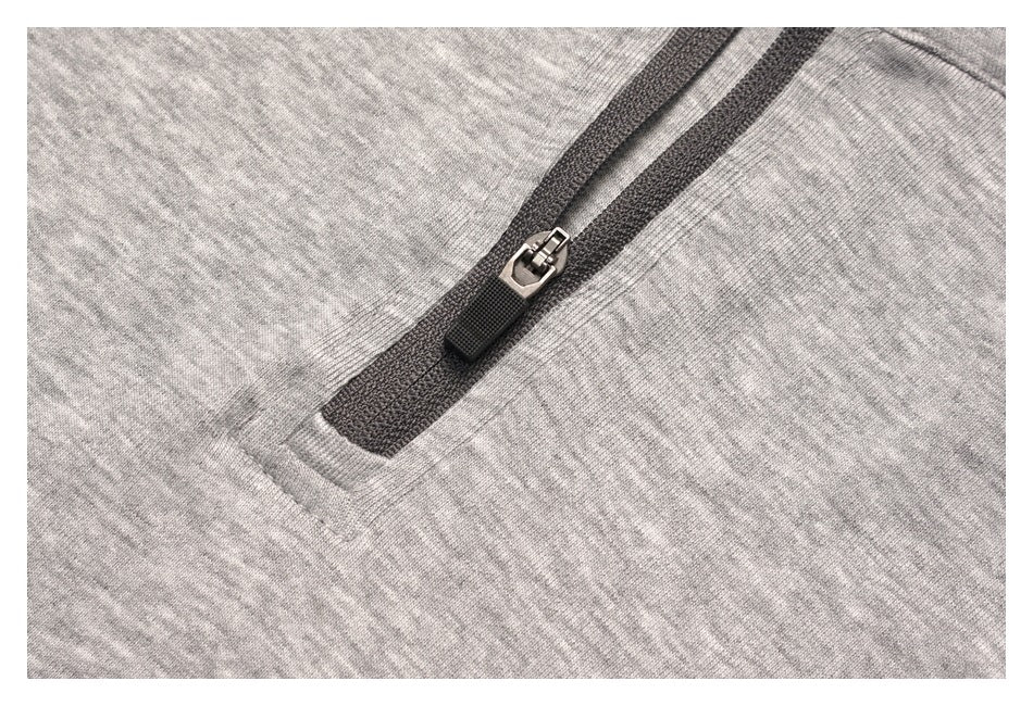 Close-up of a dark zipper and metal slider on light gray heather fabric.