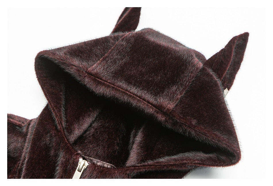 Close-up of a dark burgundy-brown plush jacket hood with pointed ear-like flaps and a glimpse of the zipper.