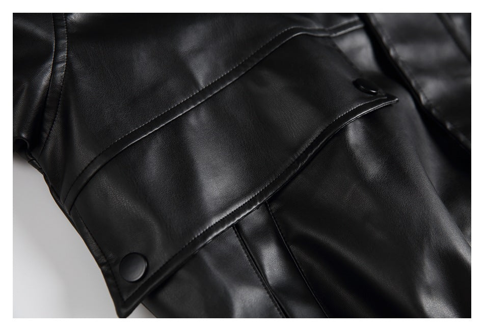 Close-up of a black jacket showing a curved flap with two snap buttons and stitched panel seams.