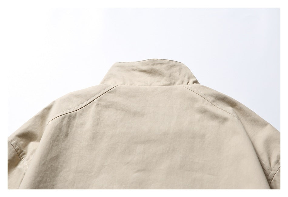 Cropped back view of a beige jacket laid flat, showing the upper back, collar and shoulder seams.