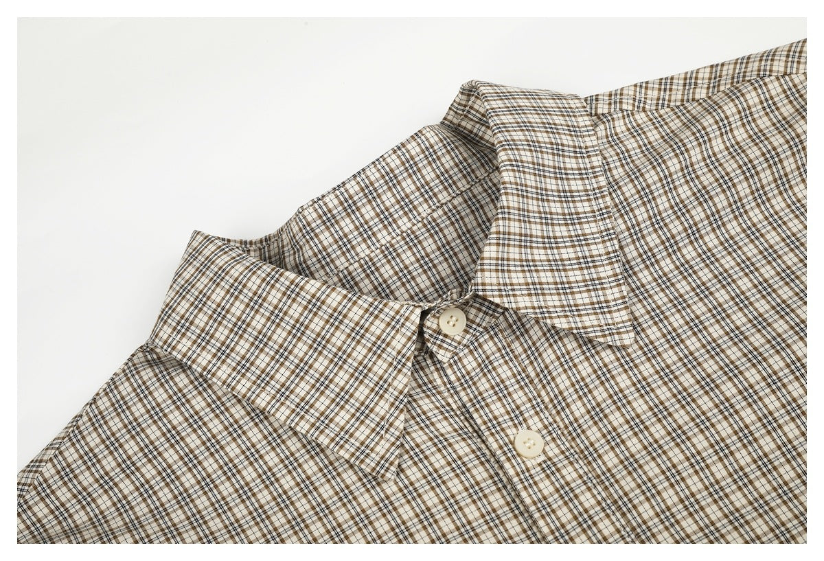 Close-up of a beige, brown, and black plaid shirt collar and upper button placket.