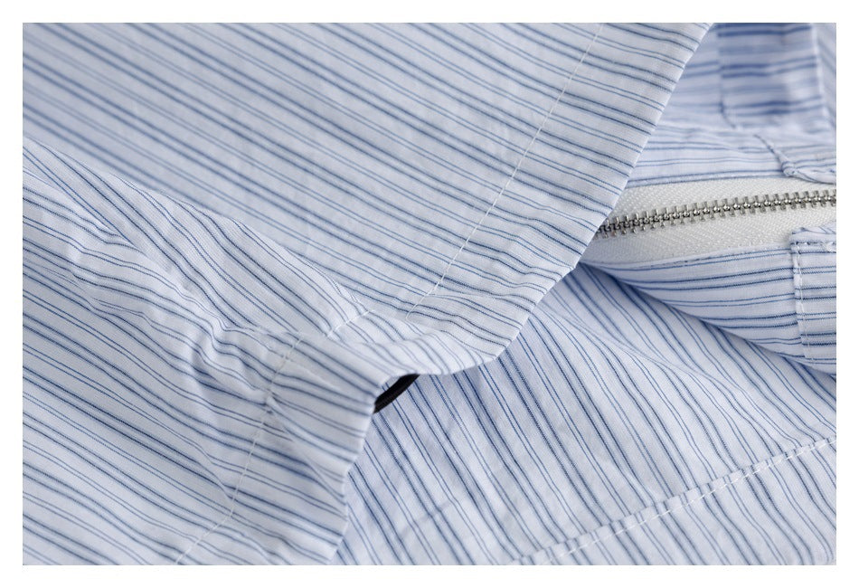 Close-up of striped white fabric beside an exposed zipper and stitched seam.