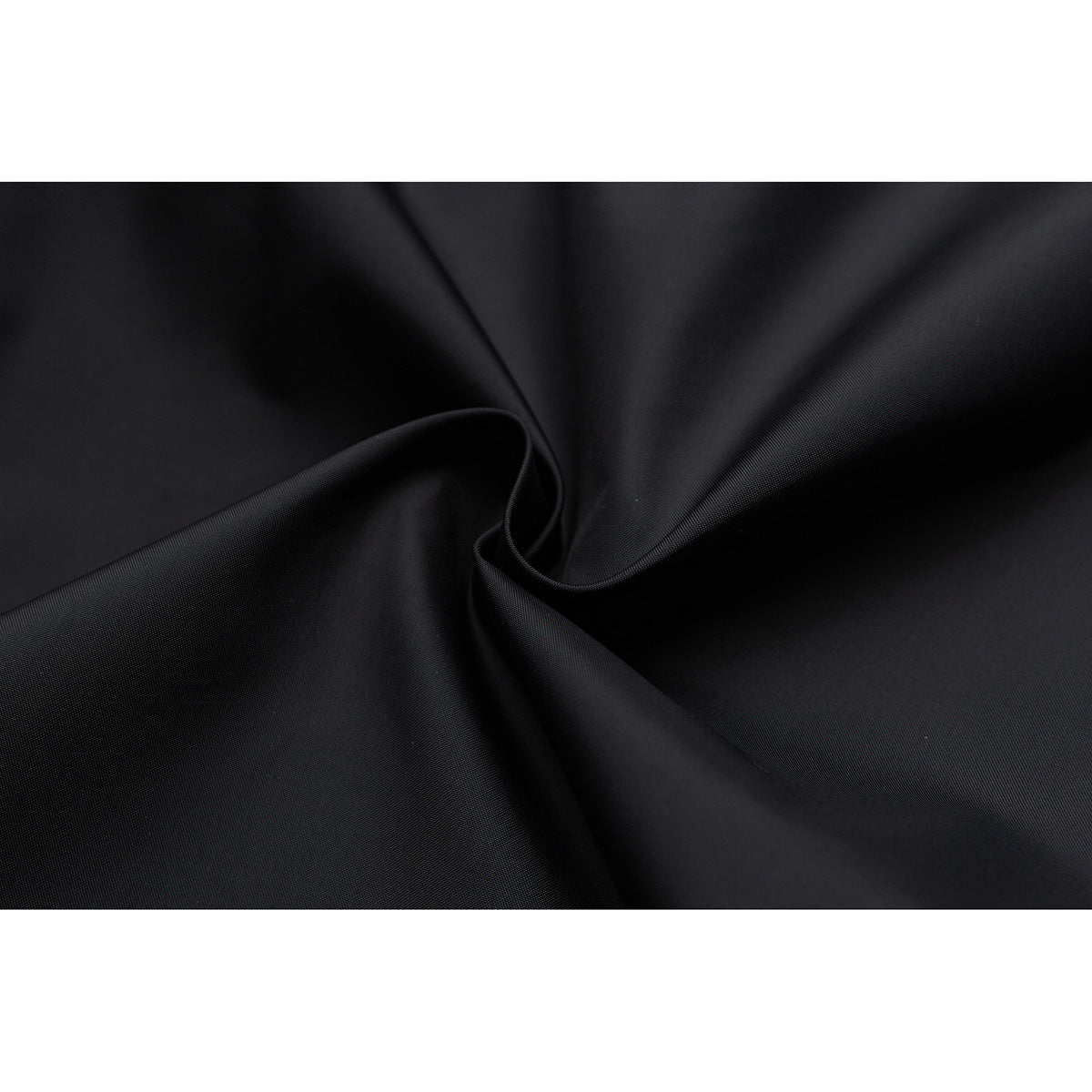Close-up of smooth black fabric gathered into soft folds.