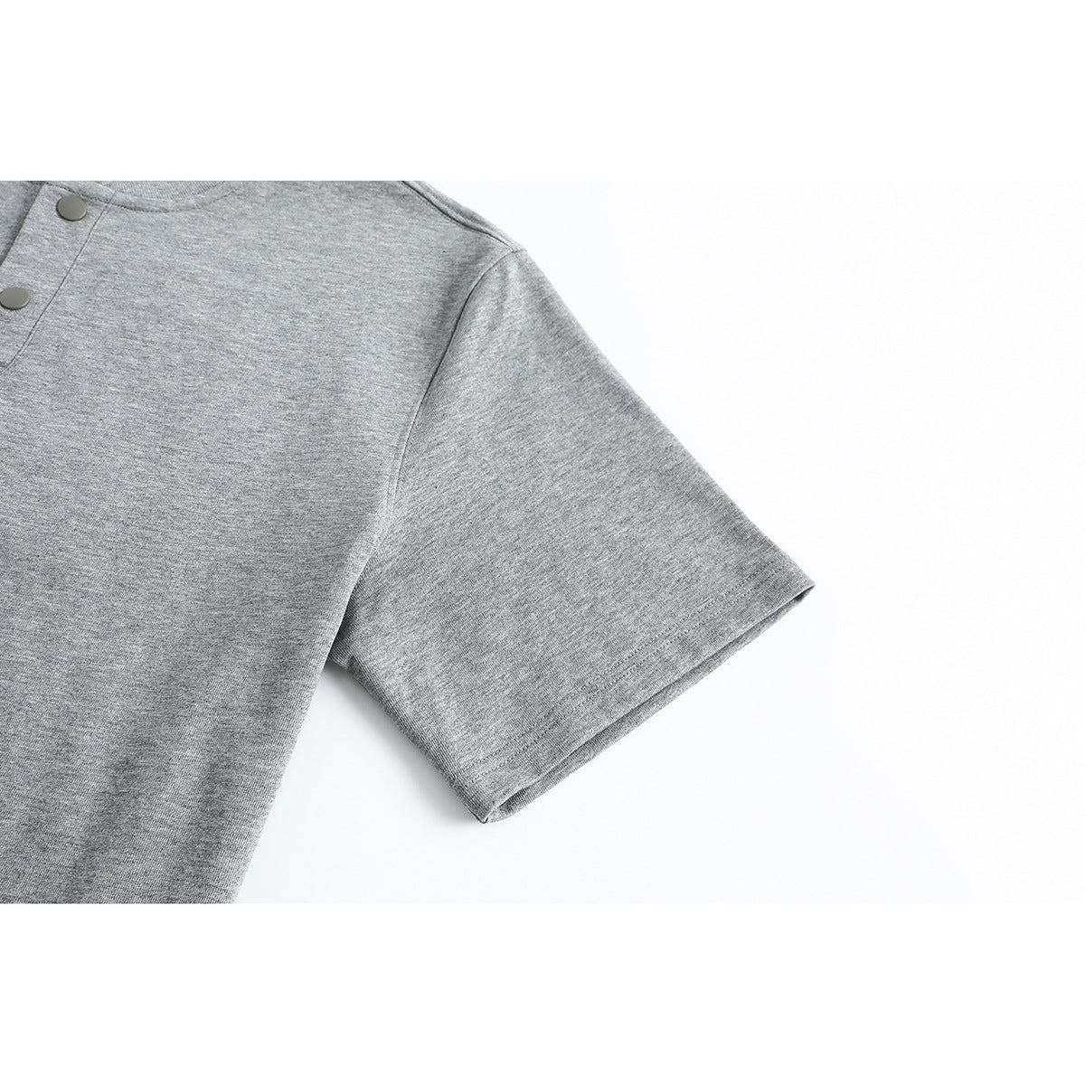 Close-up of the short sleeve and stitched hem of a heather gray T-shirt.
