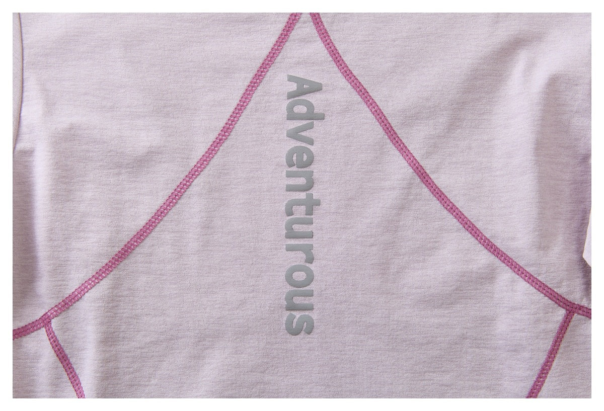 Close-up of pink seam lines and vertical gray “Adventurous” lettering on pale lavender fabric.