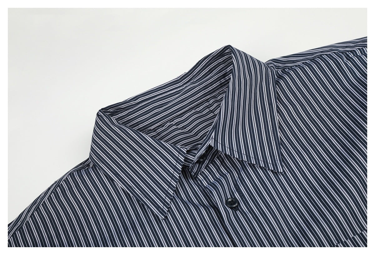 Close-up of a dark navy shirt with narrow white stripes, showing the pointed collar and upper button placket.