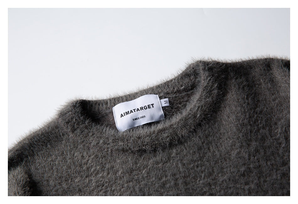 Close-up of a fuzzy charcoal-gray sweater neckline with a sewn white AIMATARGET label and size M tag.