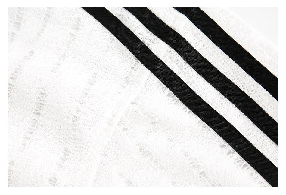 Close-up of white open-knit fabric with three black diagonal stripes.