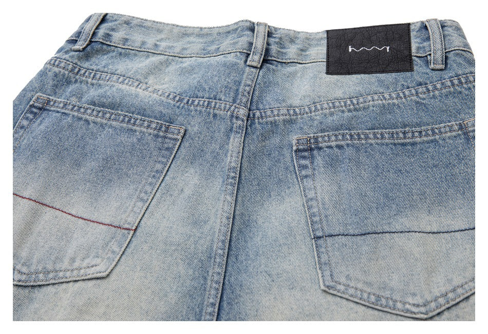 Upper back of faded light-blue jeans with two pockets, belt loops, and a black waistband patch.
