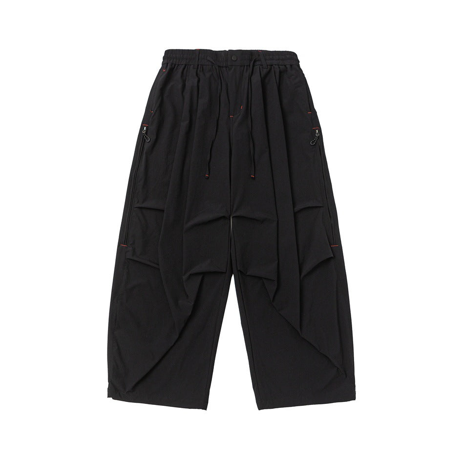 Black wide-leg pants, front flat lay with drawstring waist, pleated thighs and red contrast stitching