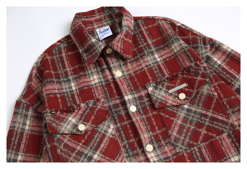 Close-up of the red tartan shirt jacket front, showing snap buttons, flap pockets, and a neck label.