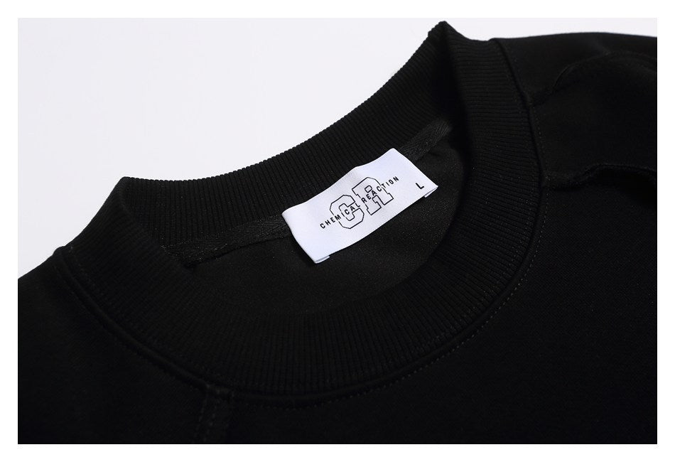 Close-up of the black crewneck sweatshirt collar and a white neck label.