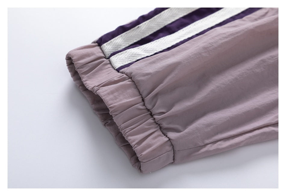 Close-up of a gathered elastic edge beside purple and white stripes on mauve fabric.