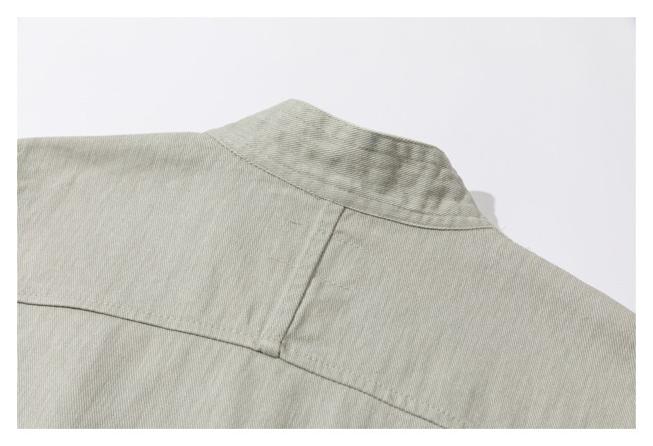 Close-up of the garment's back collar and upper yoke in pale gray-beige fabric.