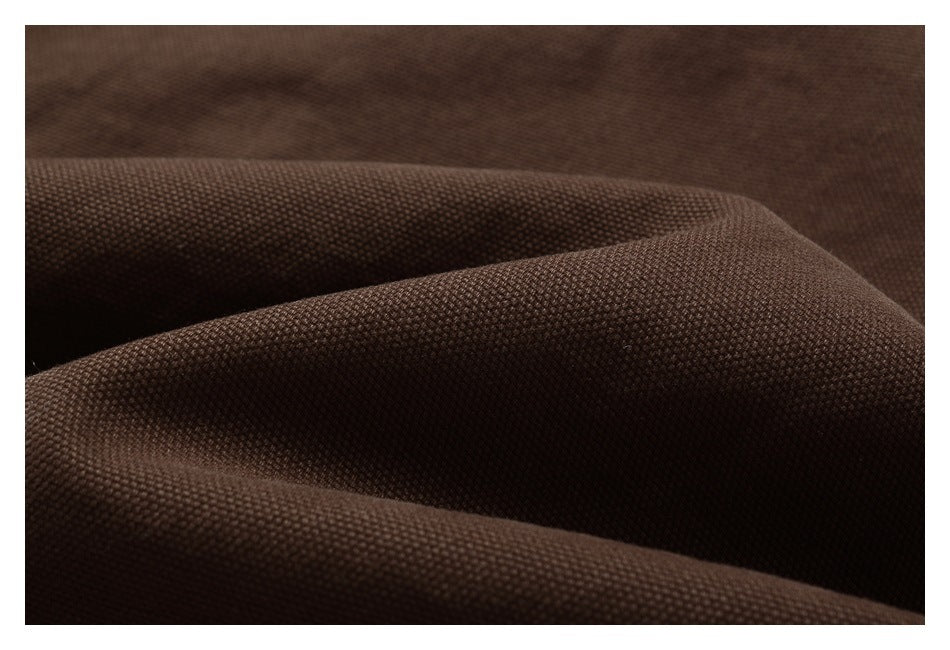 Close-up of dark brown fabric showing its fine woven texture and draped folds.