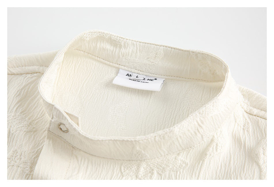 Close-up of the ivory shirt's stand collar, button detail, and sewn-in neck label.