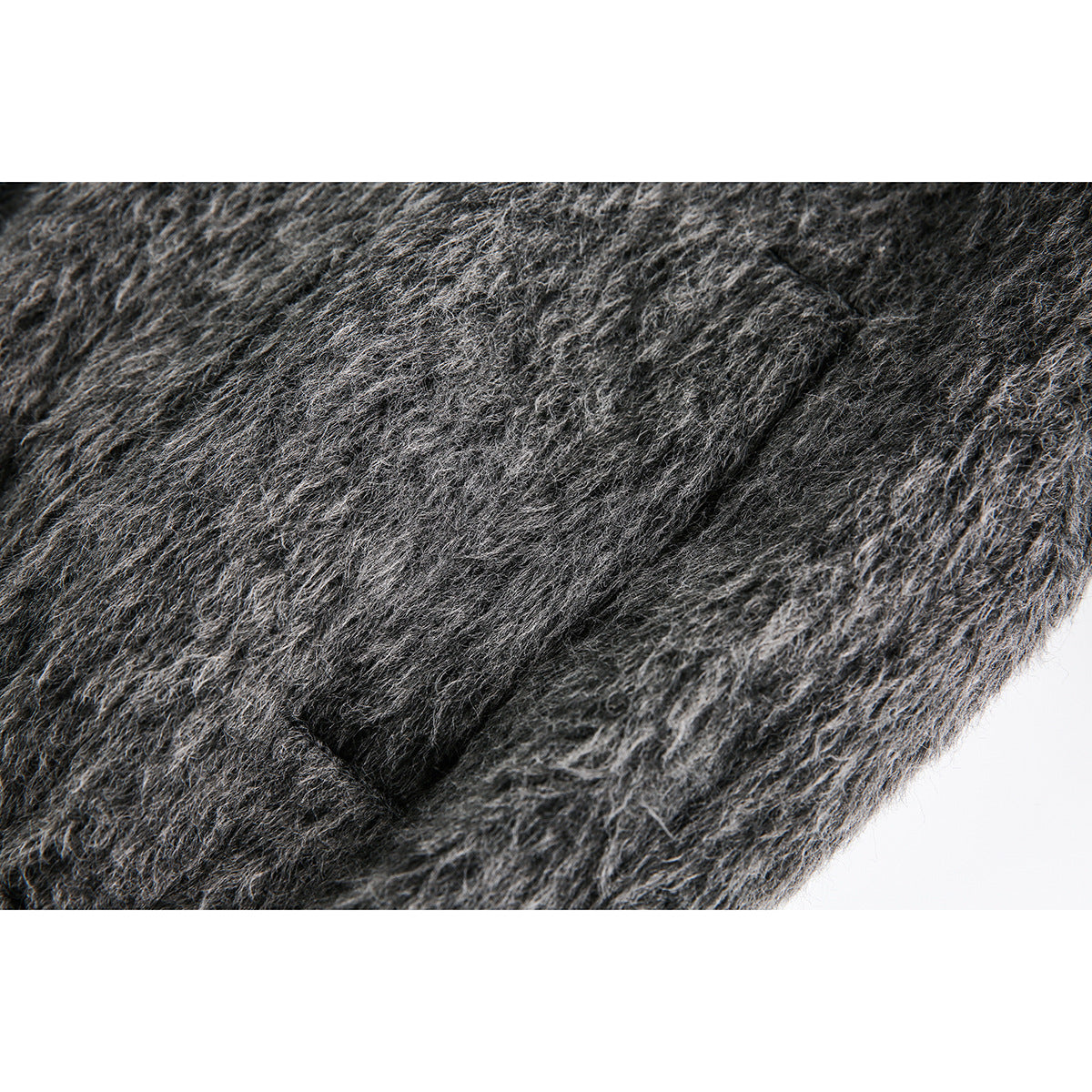 Close-up of a pocket opening in the dark gray fuzzy jacket.