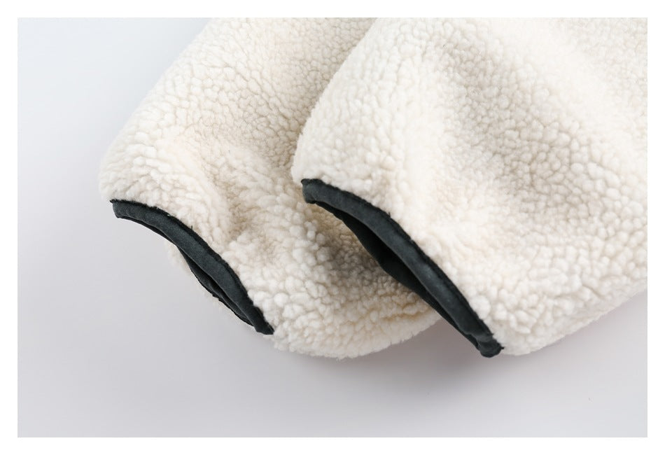 Close-up of two cream sherpa jacket sleeve openings edged with dark trim.