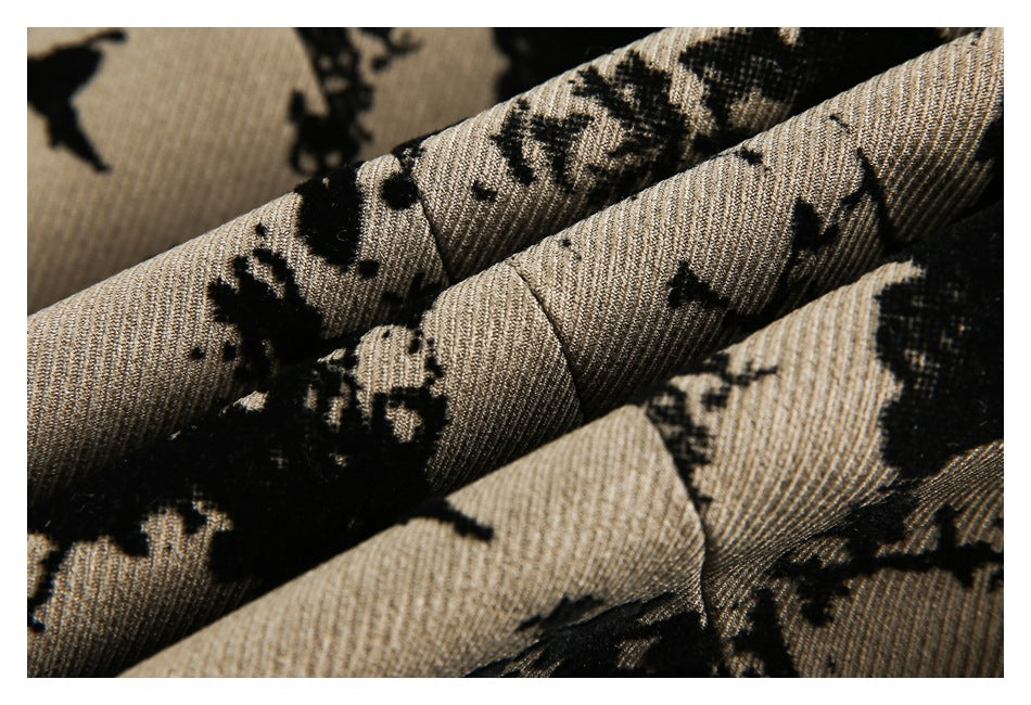 Close-up of folded beige fabric showing a black floral pattern and ribbed texture.
