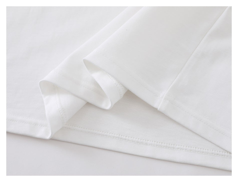 Close-up of the white shirt's sleeve cuffs and hem stitching.