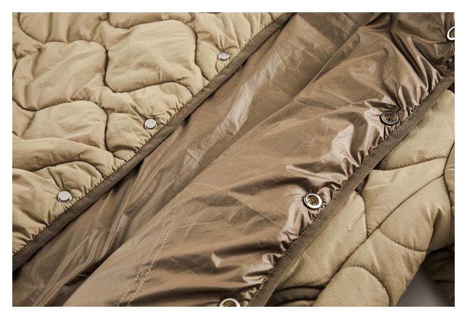 Close-up of an open beige quilted jacket with snap fasteners and a brown inner panel.