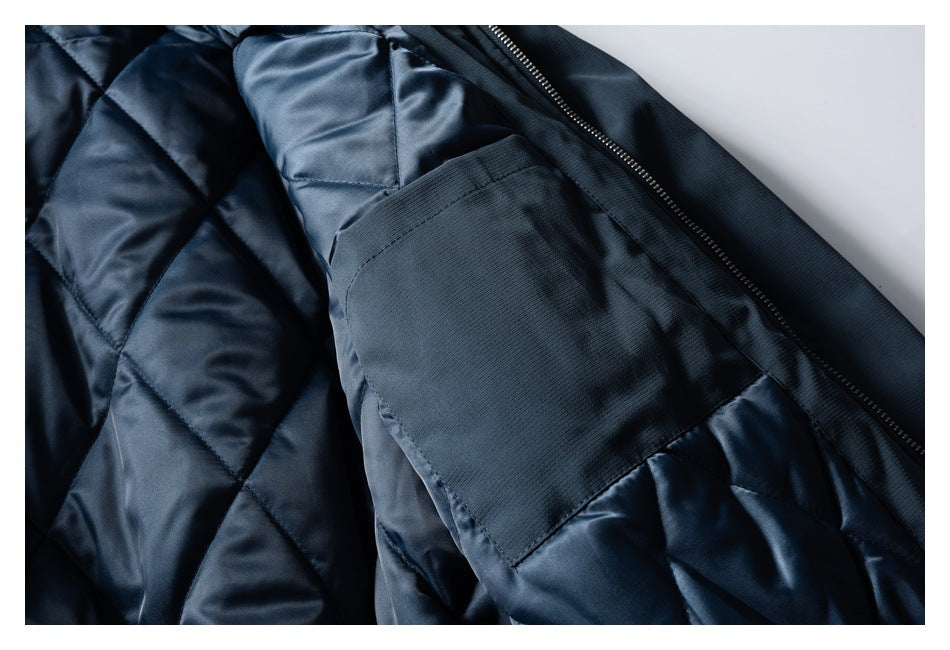 Inside of a dark navy jacket showing diamond quilting, a large patch pocket, and the front zipper.