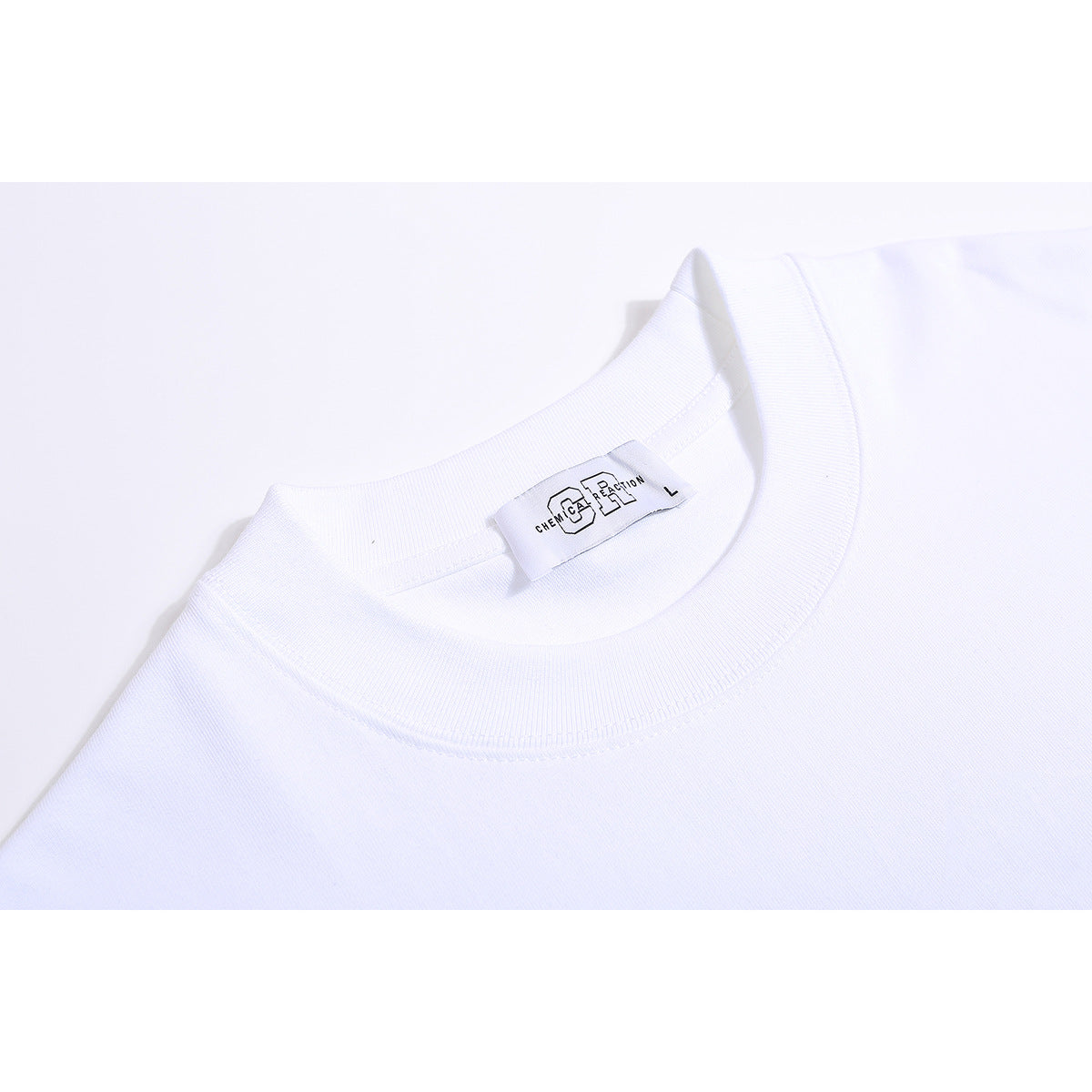 Close-up of a white T-shirt's ribbed crew neckline and sewn neck label.