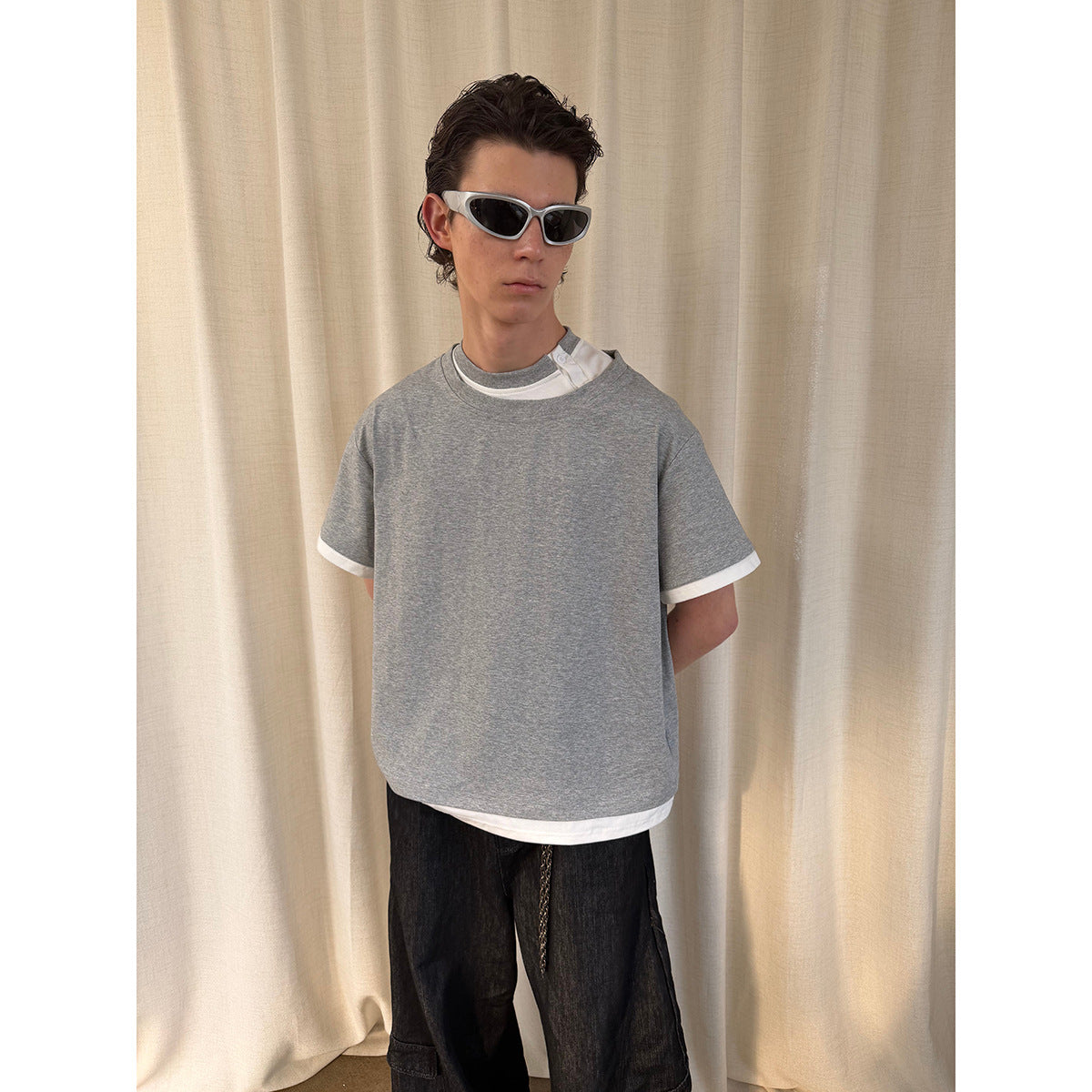 Model wearing an oversized gray short-sleeve T-shirt with white contrast trim and a visible white underlayer.