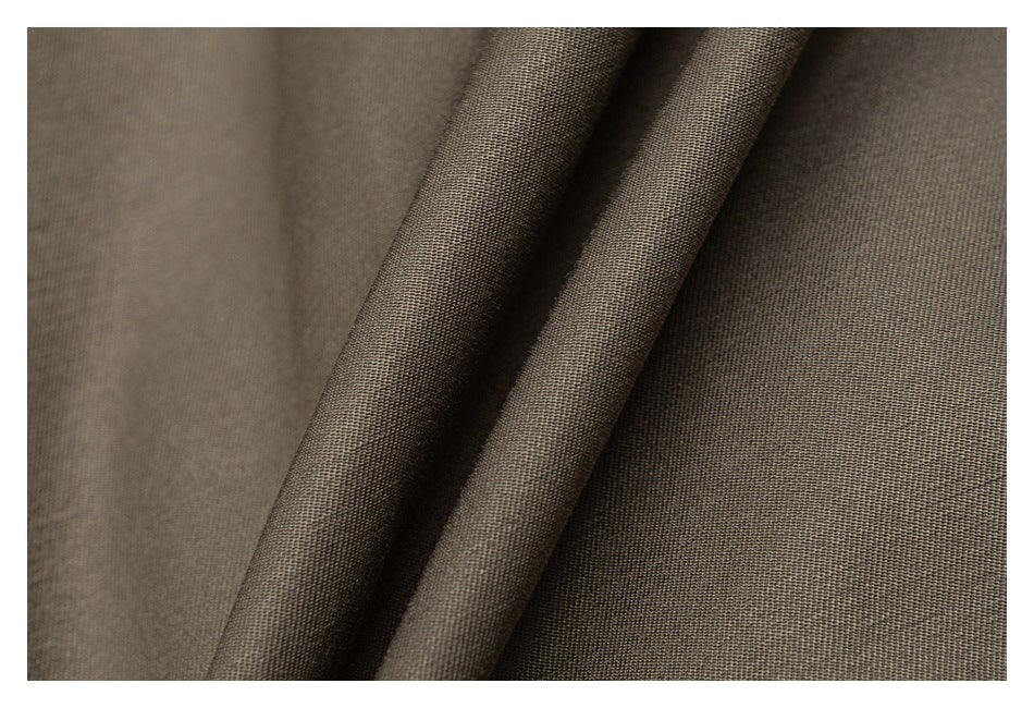 Close-up of dark taupe fabric draped to show its fine woven texture.