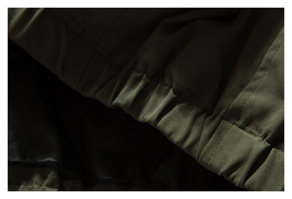 Close-up of the olive jacket's gathered hem seam and interior lining.