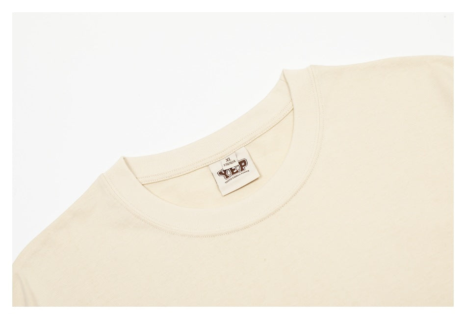 Close-up of the cream T-shirt's crew neck and sewn-in size label.
