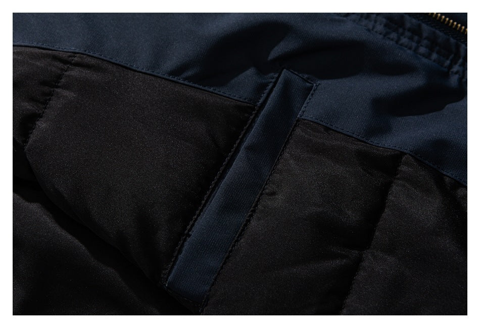 Close-up of dark navy and black garment panels with a stitched seam and narrow fabric tab.