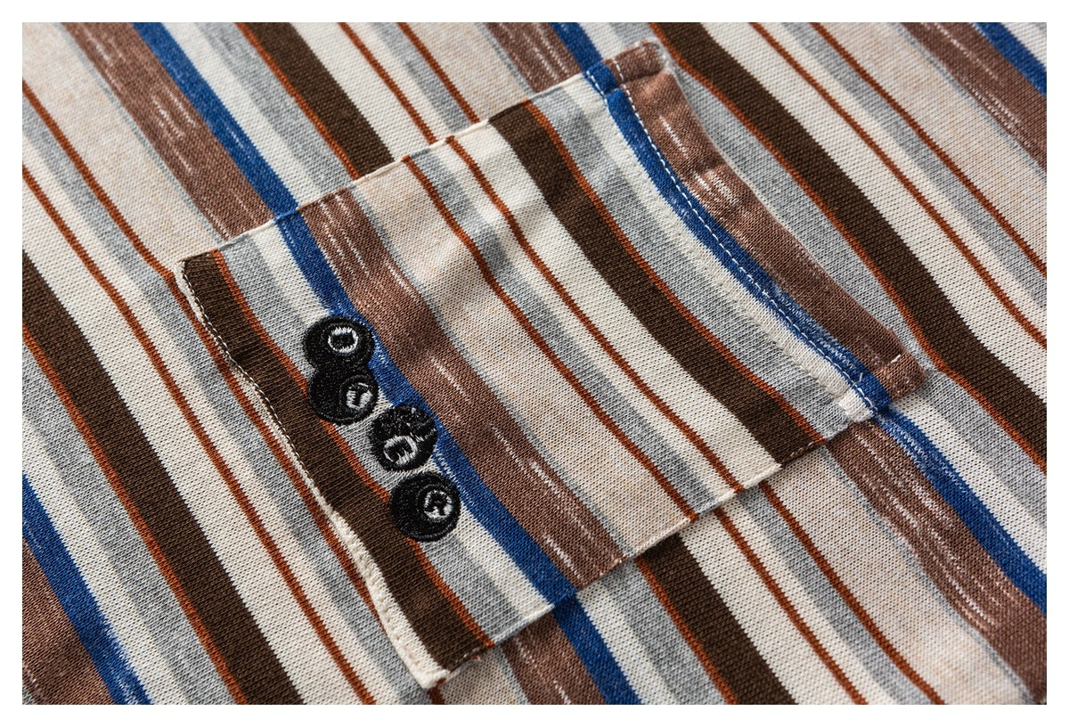 Close-up of a small pocket with four dark buttons on a cream shirt with brown, gray, and blue stripes.
