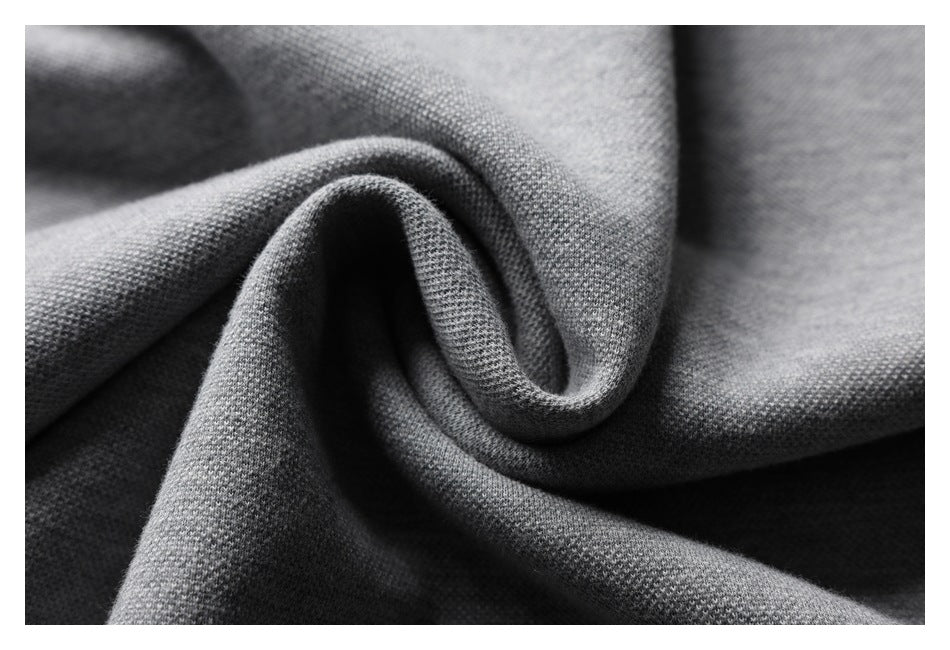 Close-up of gray knit fabric gathered into a curl, highlighting its fine textured surface.