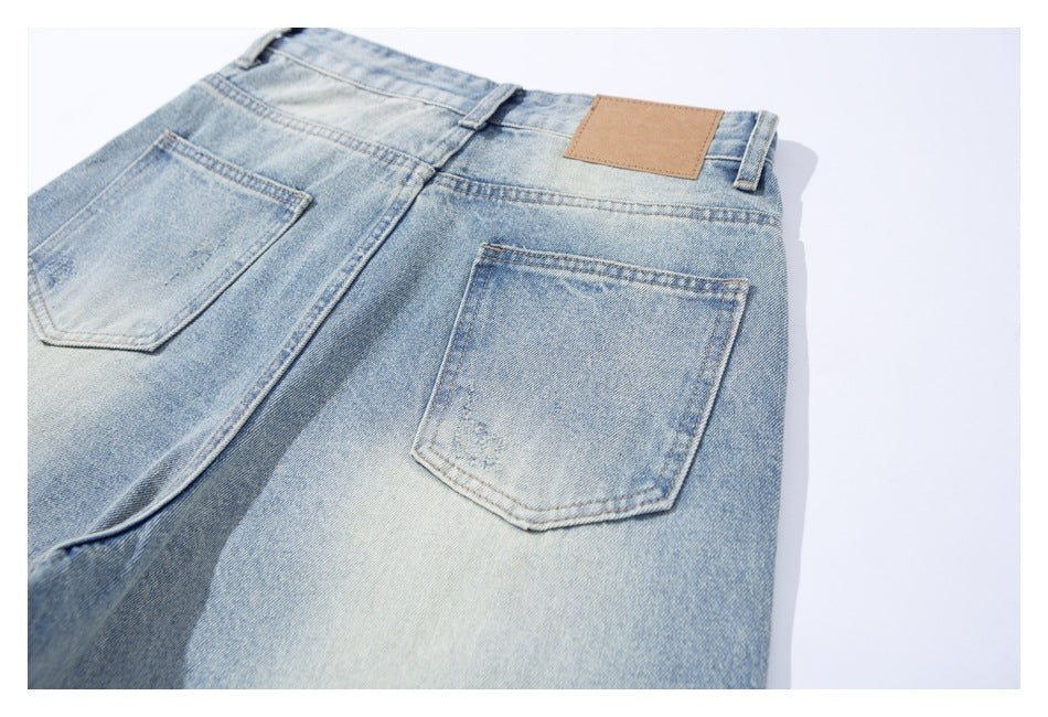 Close-up of the back of light blue washed jeans, showing two pockets and a blank tan waistband patch.